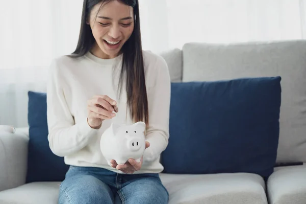 stock image Asian woman putting coin in piggy bank. Save money and investment concept