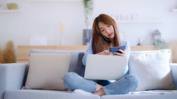 Mladá Asijská Žena Pomocí Počítače Notebook Mobilní Smartphone Zatímco Sedí — Stock fotografie