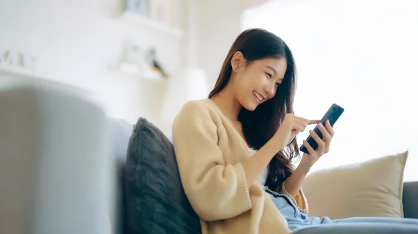 Happy Young Asian Woman Relax Comfortable Couch Home Texting Messaging — Stockfoto