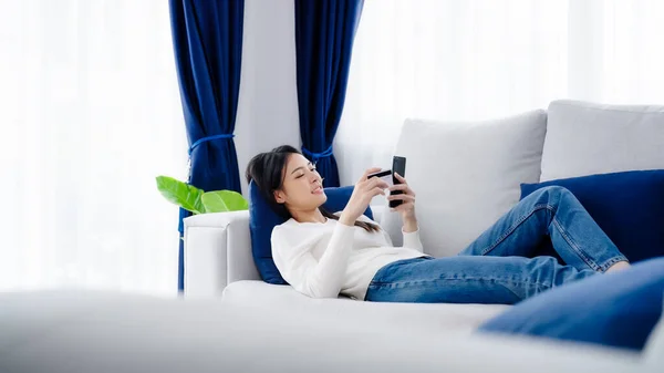 Young Asian Woman Lying Sofa Living Room Makes Online Banking — Photo