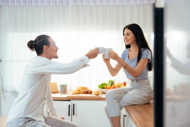 Mutlu evli koca ve kadın karı koca evde kahve içerek kutluyorlar. Sabahları kahve molası veren bir çift.