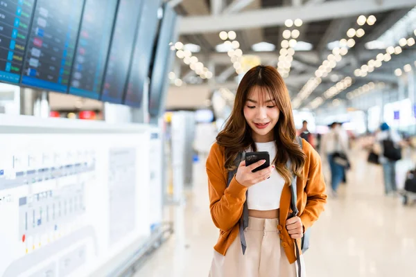 Uluslararası Havaalanındaki Genç Asyalı Kadın Cep Telefonu Kullanıyor Uçuş Bilgilerini — Stok fotoğraf
