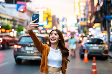 Genç Asyalı turistler selfie çekerek fotoğraf çekiyorlar. Çin Mahallesi 'nde güzel turistler Bangkok, Tayland' da