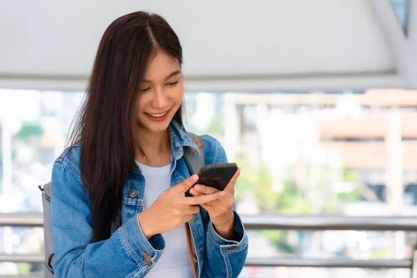 Sokakta Duran Akıllı Telefon Kullanan Asyalı Genç Bir Kadın — Stok fotoğraf