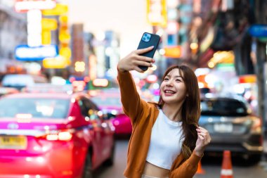 Genç Asyalı turistler selfie çekerek fotoğraf çekiyorlar. Çin Mahallesi 'nde güzel turistler Bangkok, Tayland' da