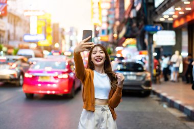 Genç Asyalı turistler selfie çekerek fotoğraf çekiyorlar. Çin Mahallesi 'nde güzel turistler Bangkok, Tayland' da
