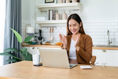 Asyalı bir kadının kazanmasını ya da bilgisayar laptopunda ecommerce alışveriş teklifi almasını kutlayan komik bir coşku. Heyecanlı mutlu kız kazanan başarıyı kutlayan deftere bakıyor.