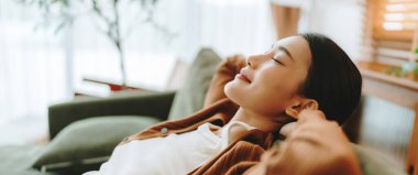 Rahat genç Asyalı kadın rahat koltukta dinleniyor, sakin çekici kız kanepede dinleniyor, temiz hava soluyor gözleri kapalı, evde meditasyon yapıyor.