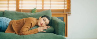 Asyalı kadın koltukta dinleniyor, işten sonra bitkin hissediyor, enerjisi yok, ya da çok çalışıyor, çok yorgun ve motivasyonsuz.