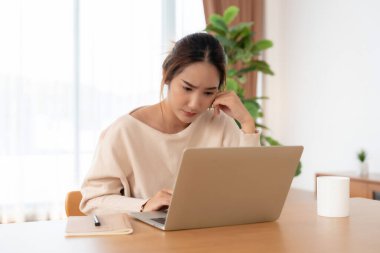 Ofis sendromu. Çok çalışan yorgun Asyalı kadın baş ağrısı çekiyor, bilgisayardan sonra görme sorunu yaşıyor. Evde yorgunluk çeken stresli genç bir kadın.