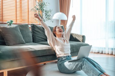 Asyalı bir kadının kazanmasını ya da bilgisayar laptopunda ecommerce alışveriş teklifi almasını kutlayan komik bir coşku. Heyecanlı mutlu kız kazanan başarıyı kutlayan deftere bakıyor.