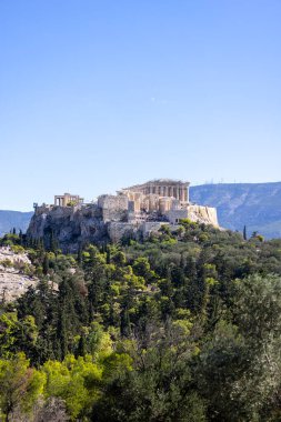 Atina, Yunanistan - 17 Ekim 2022: Muse Tepesi 'nden mavi gökyüzünün arkaplanındaki Atina Akropolü