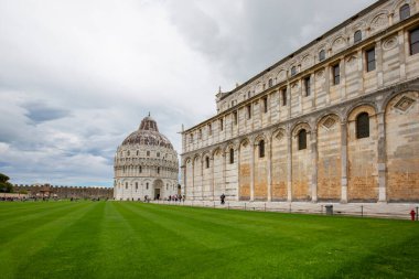 Pisa, İtalya - 13 Mayıs 2019: St. John 'daki Pisa Baptistery' den önce Piazza del Duomo 'da turistler. Pisa Katedrali ve Eğik Pisa Kulesi 'nin yanındaki 12. yüzyıl Roma Katolik kilisesi binasıdır.