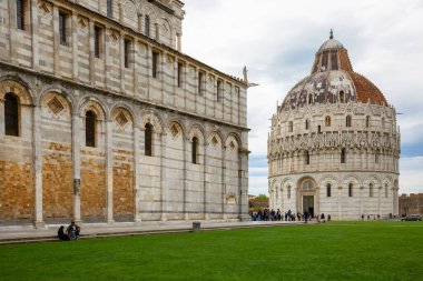 Pisa, İtalya - 13 Mayıs 2019: St. John 'daki Pisa Baptistery' den önce Piazza del Duomo 'da turistler. Pisa Katedrali ve Eğik Pisa Kulesi 'nin yanındaki 12. yüzyıl Roma Katolik kilisesi binasıdır.