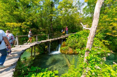 Plitvice Gölleri, Hırvatistan - 2 Eylül 2019: Plitvice Gölleri Ulusal Parkı, doğanın bir mucizesi, tahta köprüde yürüyen turistler