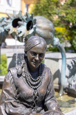 Makow Podhalanski, Polonya - 7 Ağustos 2021: Ulusal bir kostüm içindeki bir nakışçının anıtı, şehir meydanında fıskiye şeklinde işleniyor