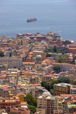 Naples, Italy - June 27, 2021: Aerial view of city with colorful buildings and port on Tyrrhenian Sea, Gulf of Naples. Ships sailing in the sea