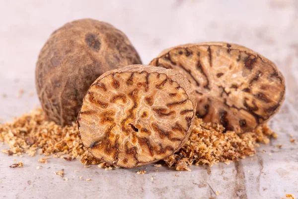 stock image Nutmeg , whole, half and powder on wooden plank, close up