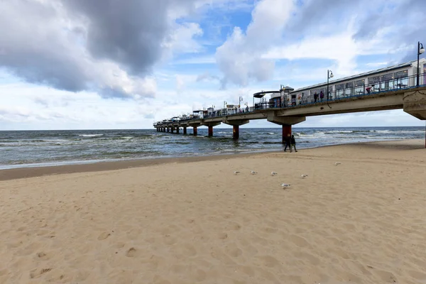 stock image Miedzyzdroje, Poland - September 15, 2022: Miedzyzdroje pier, long wooden jetty entering the Baltic Sea from the beach, beautiful seaside landscape. Cloudy sky and windy weather