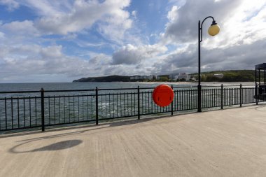 Miedzyzdroje, Polonya - 14 Eylül 2022: Miedzyzdroje iskelesi, Baltık Denizi 'ne sahilden giren uzun tahta iskele, güzel deniz manzarası. Ön planda kırmızı can simidi