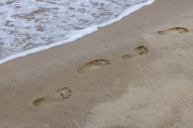Baltık Denizi, Miedzyzdroje, Wolin Adası, Polonya sahillerindeki ıslak kumda çıplak ayak izleri.