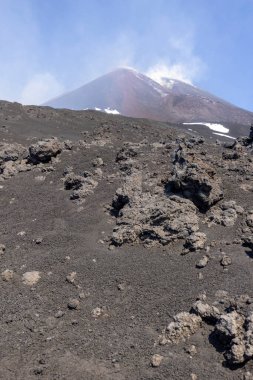 Ana kraterin dumanı tüten zirvesiyle Etna Yanardağı. Etna aktif stratovolcano, Avrupa, Sicilya, İtalya 'nın en uzun ve en büyük volkanik konisidir.