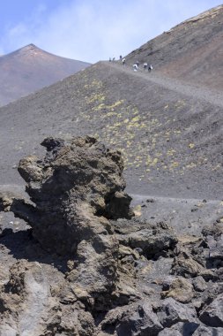 İtalya, Sicilya 'daki Etna Dağı' nın yamacında Silvestri Krateri 'nde yürüyen insanlar var. Aktif stratovolcano, Avrupa 'daki en uzun ve en büyük volkanik konidir.