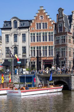 Gent, Belçika - 19 Mayıs 2023: Lys Nehri üzerindeki Grasbrug Köprüsü (Leie), renkli evler ve denizde seyahat gemileri.