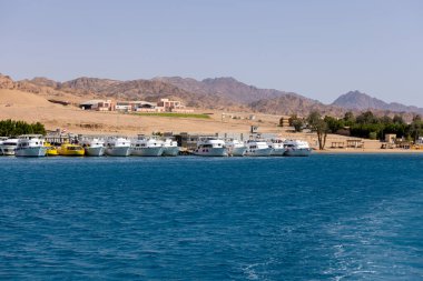 Dahab, Mısır - 10 Eylül 2021: limana demirlemiş dalış botlarının görüntüsü. Dahad, dağlarla çevrili eski bir Bedevi köyü. Şimdi Mısır 'ın en değerli dalış alanlarından biri.
