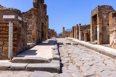 Pompeii, Napoli, İtalya - 26 Haziran 2021: M.S. 79 'da Napoli yakınlarında Vesuvius volkanının patlaması sonucu yıkılan antik bir şehrin kalıntıları. Şehir sokaklarından birinin manzarası