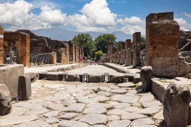 Pompeii, Napoli, İtalya - 26 Haziran 2021: M.S. 79 'da Napoli yakınlarında Vesuvius volkanının patlaması sonucu yıkılan antik bir şehrin kalıntıları. Şehir sokaklarından birinin manzarası