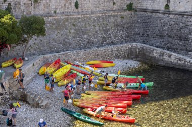 Dubrovnik, Hırvatistan - 27 Haziran 2023: Adriyatik Denizi kıyısındaki Old Walls ve Bokar kulesindeki renkli kano gezileri için marina manzarası