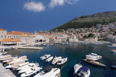 Dubrovnik, Hırvatistan - 27 Haziran 2023: Adriyatik Denizi 'nin demirlemiş gemileri ve şehir surlarıyla birlikte ortaçağ antik limanına (Stara Luka) bakış
