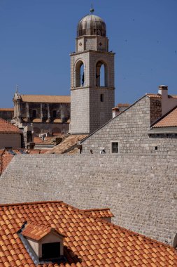 Dubrovnik, Hırvatistan - 27 Haziran 2023: Adriyatik Denizi 'ndeki ortaçağ kentini çevreleyen Saat Kulesi ile Kent Duvarları manzarası. Tarihi merkezi olan Eski Şehir Dalmaçya 'nın incisi olarak bilinir.