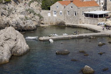 Dubrovnik, Hırvatistan - 27 Haziran 2023: Dubrovnik Batı Limanı Eski Duvarlar yakınlarındaki Adriyatik Denizi kıyısında küçük bir taş iskeleye sahip
