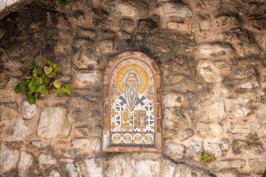 Budva, Karadağ - 28 Haziran 2023: Taş Pizanela kapısı önünde bir ortodoks azizin mozaiği, limandan eski kente giriş