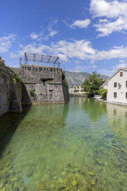 Kotor, Karadağ - 26 Haziran 2023: Scurda Nehri ve Bembo Kalesi 'nden nehir kapısına (Kuzey Kapısı) uzanan ortaçağ taş şehir duvarları)