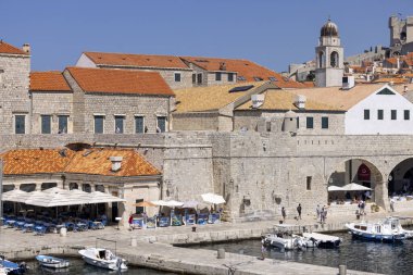 Dubrovnik, Hırvatistan - 27 Haziran 2023: Adriyatik Denizi 'nin demirlemiş gemileri ve şehir surlarıyla birlikte ortaçağ antik limanına (Stara Luka) bakış