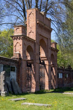 Lodz, Polonya - 4 Mayıs 2023 Lodz Yahudi Mezarlığı, Lodz Getto kurbanlarının mezar taşları ve toplu mezarları. Lapidarium ve iç kapılı kırmızı tuğla duvar 