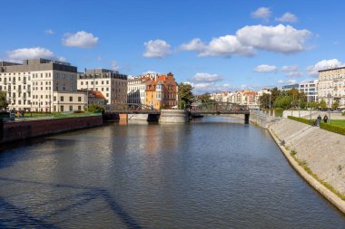 Wroclaw, Polonya - 30 Eylül 2021: Odra Nehri ve Değirmen Köprüsü manzarası. Arka planda renkli konutlar