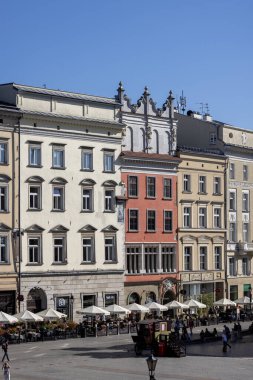 Krakow, Polonya - 6 Eylül 2023: Ana pazar meydanının havadan görünüşü, renkli apartmanlar. İnsanlar pazar meydanında yürüyorlar