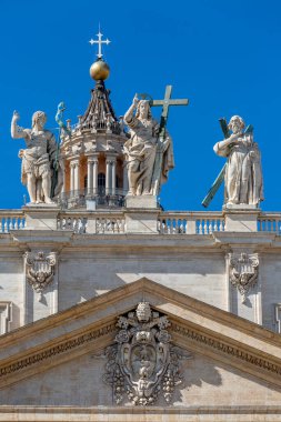 Vatikan, Roma, İtalya - 9 Ekim 2020: Aziz Petrus Bazilikası 'nın tepesinde İsa figürü, apastoller ve mavi gökyüzünün arka planında yer alan Aziz Peter Meydanı' ndaki arması.