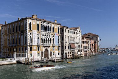 Venedik, İtalya - 27 Eylül 2023: Büyük Kanal, deniz kenarında tarihi dekoratif konutlar, yüzen tekneler. Canal Grande, 3.8 km uzunluğundaki kentin en büyük su trafiği koridorlarından biridir.
