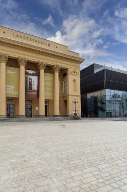 Innsbruck, Avusturya - 26 Şubat 2023: 17. yüzyıl Tyrolean Devlet Tiyatrosu (Tiroler Landestheater Innsbruck) ve modern Müzik Evi Rennplatz Meydanı 'nda yer almaktadır.