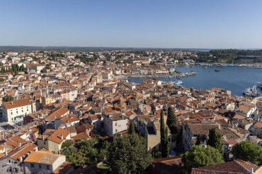 Rovinj; Hırvatistan; Istria - 29 Eylül 2023: Limanda demirlemiş tekneleri olan Saint Euphemia Kilisesi 'nin çan kulesinden hava manzarası. Tipik kırmızı seramik çatı fayansı.