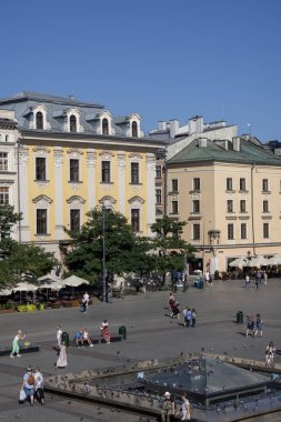 Krakow, Polonya - 6 Eylül 2023: Ana pazar meydanının havadan görünüşü, renkli apartmanlar. İnsanlar pazar meydanında yürüyorlar