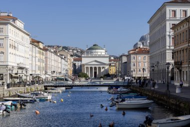 Trieste, İtalya - 26 Eylül 2023: Bulvarda demirli teknelerle Grand Canal (Canal Grande Trieste) manzarası. Kanalın sonundaki Sant 'Antonio Taumaturgo Kilisesi