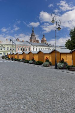 Nowy Sacz, Polonya - 30 Ağustos 2022: Güneşli bir günde Pazar Meydanı manzarası. Polonya 'nın güneyindeki Küçük Voyvoda' da bir şehirdir. Uzakta St. Malgorzata Üniversite Bazilikası 'nın kuleleri 