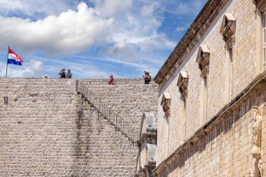 Dubrovnik, Hırvatistan - 27 Haziran 2023: Adriyatik Denizi kıyısındaki ortaçağ kentini çevreleyen Eski Duvarlar etrafındaki turist yürüyüş rotası