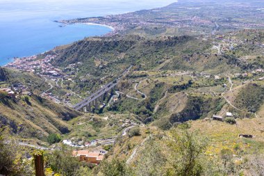 Mola Kalesi, Castelmola, Sicilya, İtalya 'dan İyon Denizi körfezi üzerindeki şehir manzarası. A18 Messina Yolu - Catania karayolu viyadük